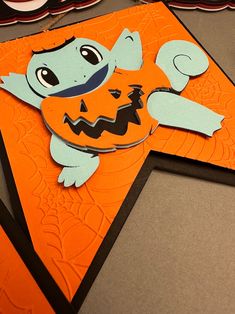 an orange and black halloween card with a cartoon character on it's front corner