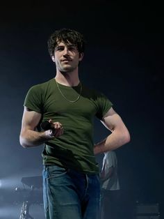 a man standing on stage with his hands in his pockets