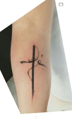 a cross tattoo on the left arm with scissors in it, and an arrow at the center