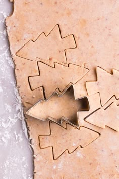 cookie cutters shaped like christmas trees sitting on top of a piece of parchment paper