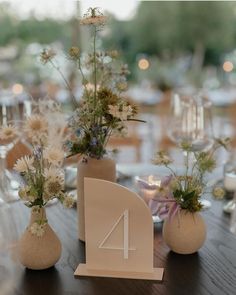 the table is set up with vases and flowers on it for an elegant wedding reception