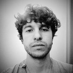 a man with curly hair looking at the camera