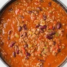 a pot filled with chili and beans on top of a stove