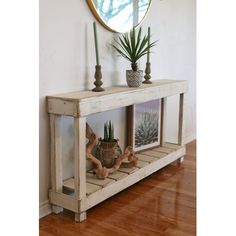 a wooden shelf with potted plants on top and a mirror above it in a room