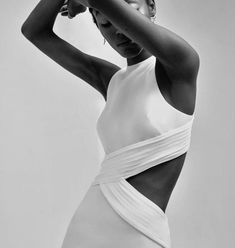 a black and white photo of a woman with her hands on her head, wearing a one piece swimsuit