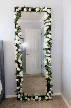 a mirror that has flowers on it in front of a door and carpeted floor