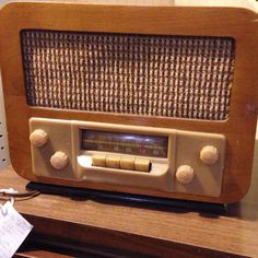 an old radio sitting on top of a wooden table