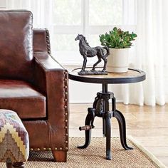 a brown leather chair sitting next to a table with a horse figurine on it