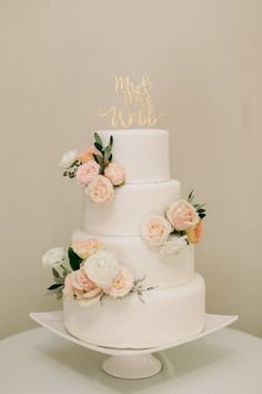 a white wedding cake with flowers on top