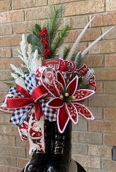 a boot decorated with red, white and black ribbon sitting on top of a table