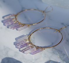 "These luxurious chandelier hoop earrings come in your choice of 14k gold fill, 14k rose gold fill or sterling silver, and are adorned with 6 genuine crystal points. You get to pick your crystals: 💜Amethyst- Calming Crystal Quartz- Purifying 💗Rose Quartz- Loving 🖤Smoky Quartz- Grounding *You also get to choose sterling silver, 14k rose gold filled or 14k gold filled hoops and components* Hoops are 2 inches in diameter and crystal points are about .75 inches long. Total earring length includin Crystal Earring Ideas, Handmade Hoop Crystal Earrings For Party, Hoop Crystal Earrings For Gifts, Gold Hoop Crystal Earrings For Gift, Crystal Jewelry Aesthetic, Handmade Bohemian Crystal Hoop Earrings, Gold Wire Wrapped Hoop Crystal Earrings, Crystal Jewelry Design, Crystals Amethyst