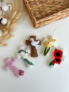 some felt flowers are sitting next to a basket and cotton floss on the table