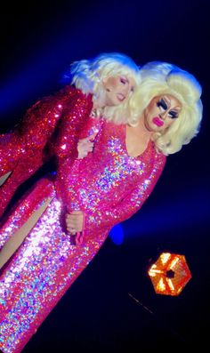 two women dressed in pink sequins posing for the camera