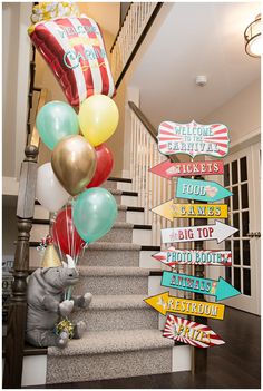 a bunch of balloons that are on the stairs in front of a staircase with signs