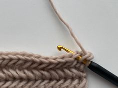 a crochet hook is hooked up to a piece of yarn