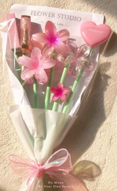 a bouquet of pink flowers in a cellophane wrap with a heart on the side