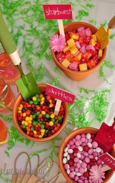 three bowls filled with candy sitting on top of a table next to other candies