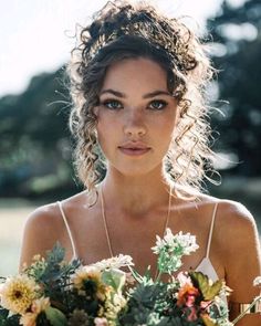 a woman holding a bouquet of flowers in her hands