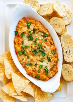 a white plate topped with tortilla chips and a dip