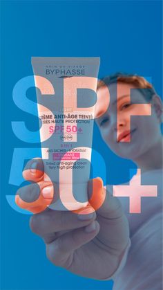 a woman holding up a plastic tube in front of her face with the words spf sun on it