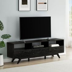 a flat screen tv sitting on top of a wooden entertainment center in a living room