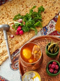 an assortment of food and drinks on a table with matriagh bread in the background