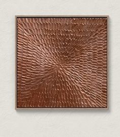 a square metal plaque mounted to the side of a wall with copper foil on it