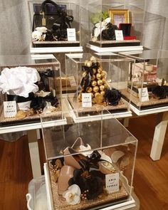 a display case filled with lots of different types of purses and handbags on top of wooden flooring