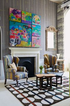 a living room filled with furniture and paintings on the wall above it's fireplace