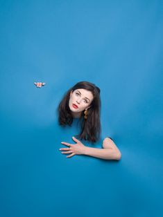 a woman is laying on the ground with her hands out and two birds flying overhead