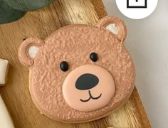 a teddy bear cookie sitting on top of a wooden table