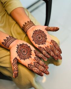 a woman's hands with henna tattoos on them