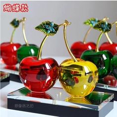 three colorful glass cherries sitting on top of each other