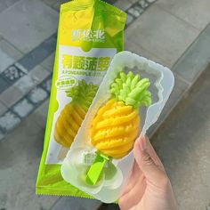 a person holding up a plastic bag with some fruit in it