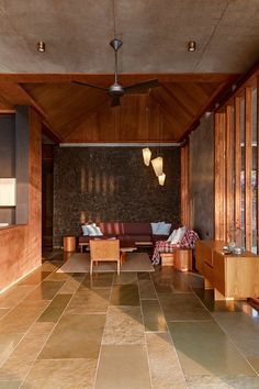 a living room with wood paneling and tile flooring on the walls is shown