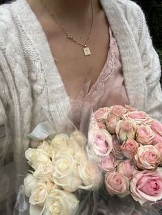 a woman holding a bouquet of pink and white roses