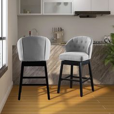 two chairs sitting next to each other in front of a kitchen counter with white cabinets