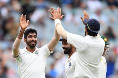 two men in white uniforms are high fiving each other with their hands up as they walk off the field