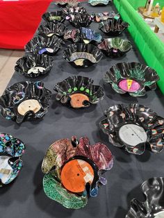 a table topped with lots of black plates covered in different designs and colors on top of it