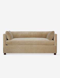 a beige couch with two pillows on the back and one arm up against it's head