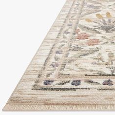 a beige rug with an ornate design on the bottom and fringes around the edges