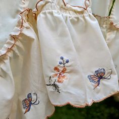 some white curtains with embroidered butterflies on them