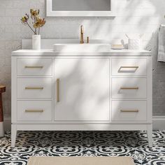 a white bathroom vanity with gold handles and drawers