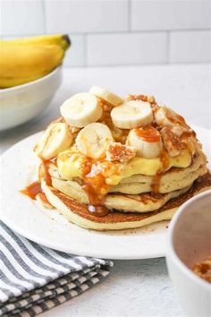 a stack of pancakes topped with bananas and syrup