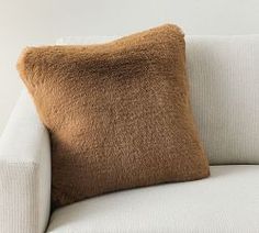 a brown pillow sitting on top of a white couch