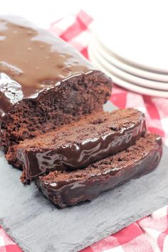 there is a chocolate cake on the table with slices cut out and ready to be eaten