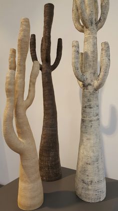 three different types of carved wood trees on display