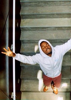 a black and white photo of a person on some stairs with their arms out in the air