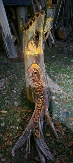 a tree stump with a lit up bird house on it