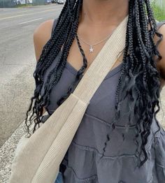 a woman with long braids standing on the street